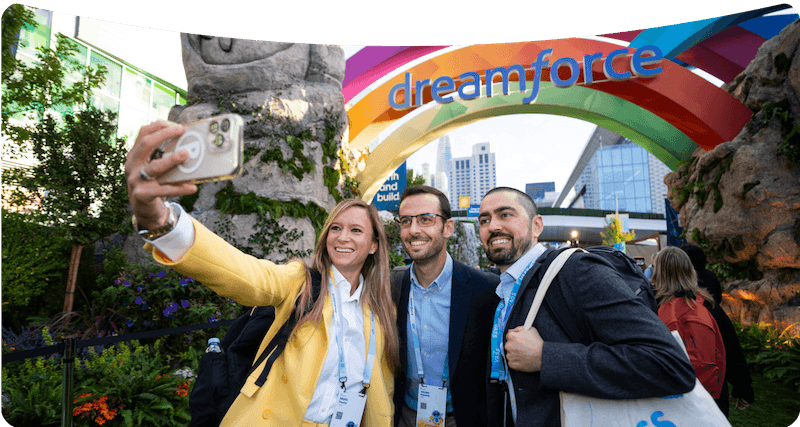 Three Dreamforce guests taking a selfie before a colorful Dreamforce entrance.
