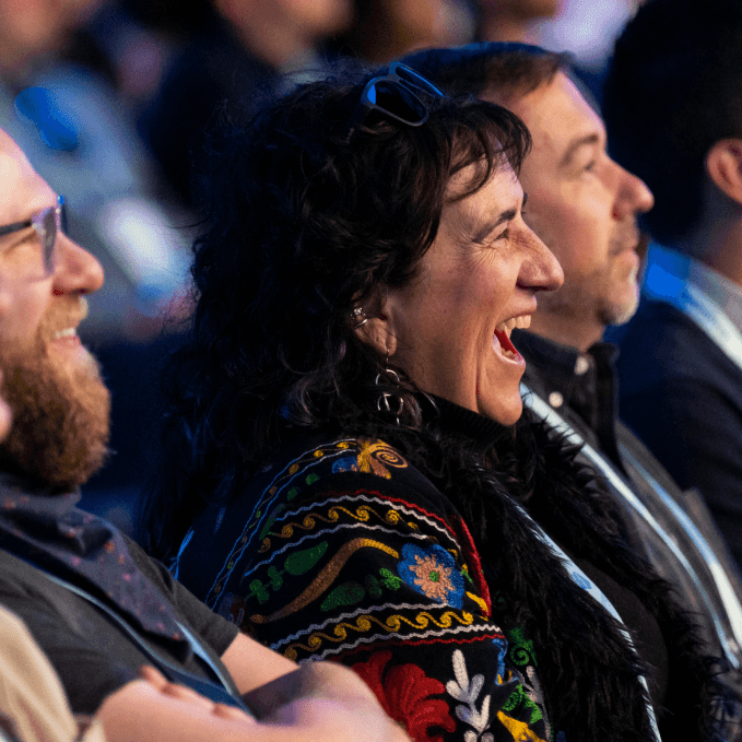 A close-up of audience members laughing and enjoying a moment at a live event.